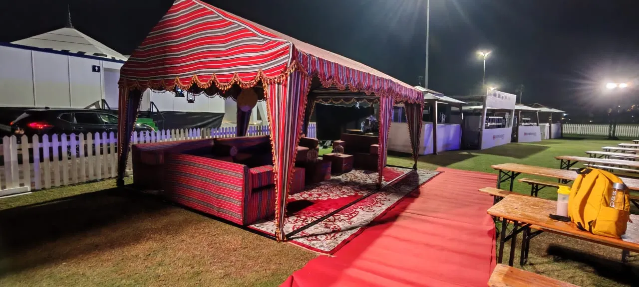 Arabic majlis tent with red sadu fabric at an outdoor event in Dubai